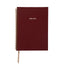 Maroon planner with gold spiral binding on a white background