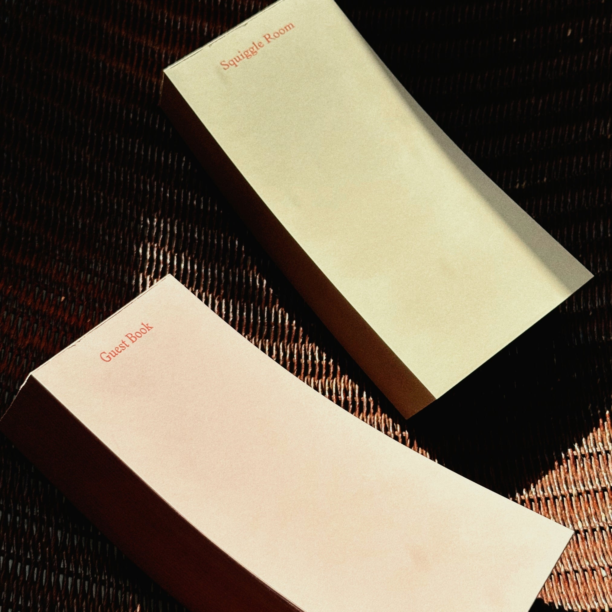 Two beige to do pads with 'Guest Room' text on a textured surface
